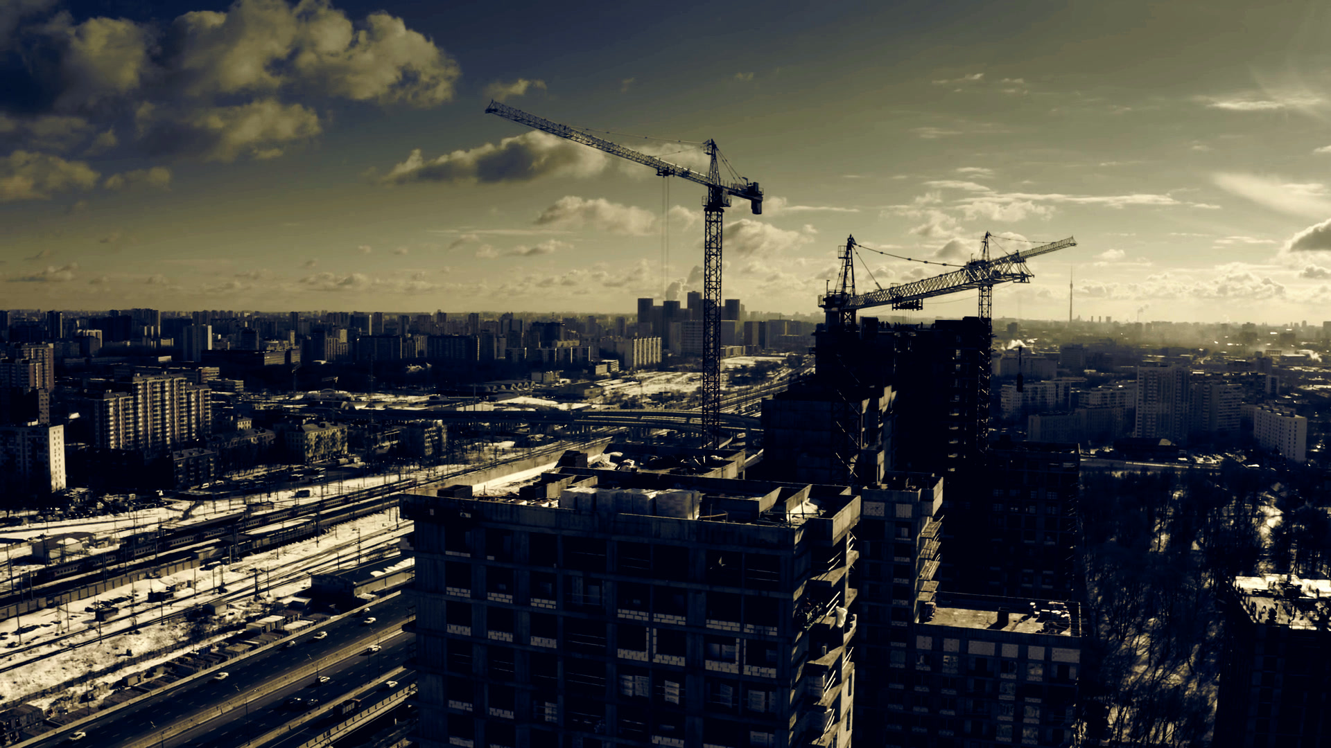 Chantier de construction résidentielle moderne — coucher de soleil sur grues et immeubles